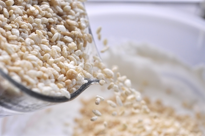 pouring rice krispies into melted marshmallows
