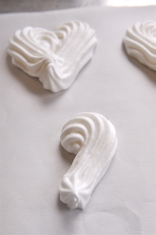 Meringue Hearts piped on parchment paper