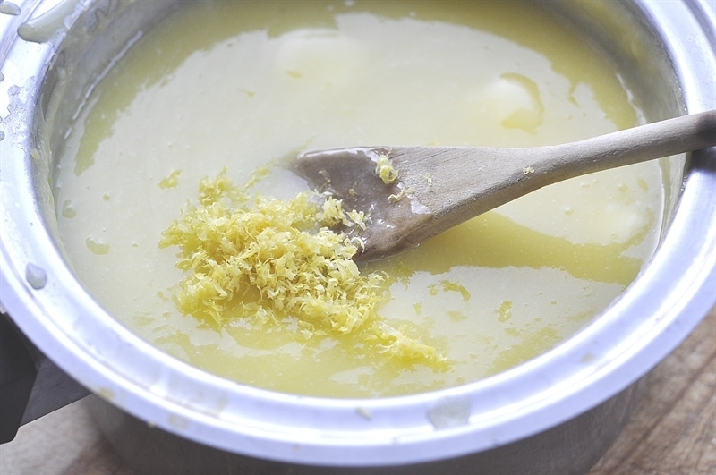 adding lemon zest to the pan of homemade lemon curd