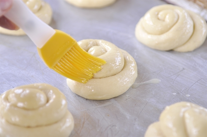 brushing roll dough with lemon curd
