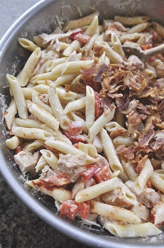 penne chicken bacon red bell peppers light cream sauce in a mixing bowl