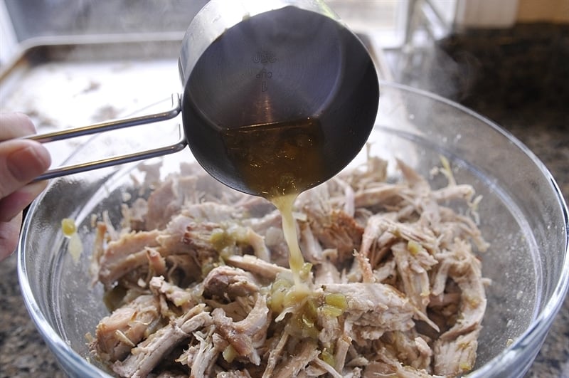 pouring salsa verde sauce over pork