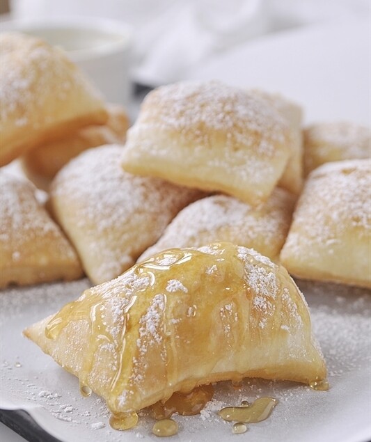 pile of pioneer scones with powdered sugar on top