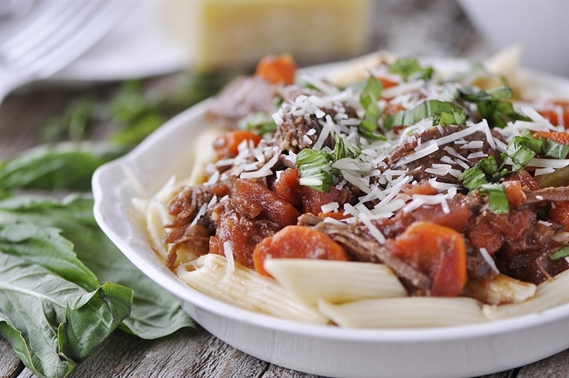 Slow Cooker Beef Ragu garnished with cheese and basil