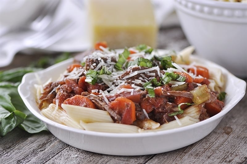 Slow Cooker Beef Ragu topped with parmesan and basil