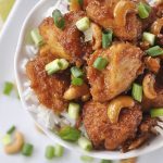 white bowl of cashew chicken with green onions on top