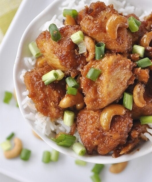 white bowl of cashew chicken with green onions on top