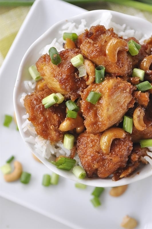 white bowl of cashew chicken with green onions on top