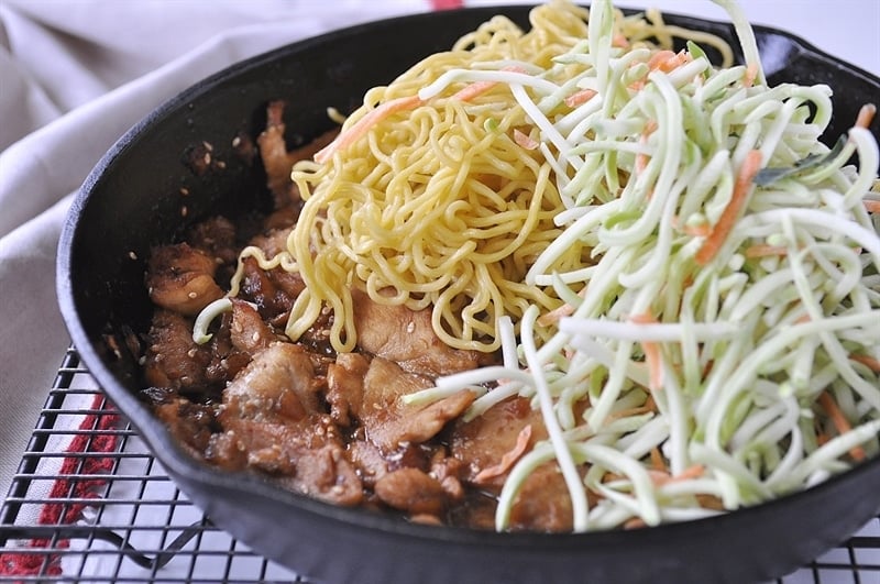 pan of stir fry chicken with yakisoba noodles and slaw