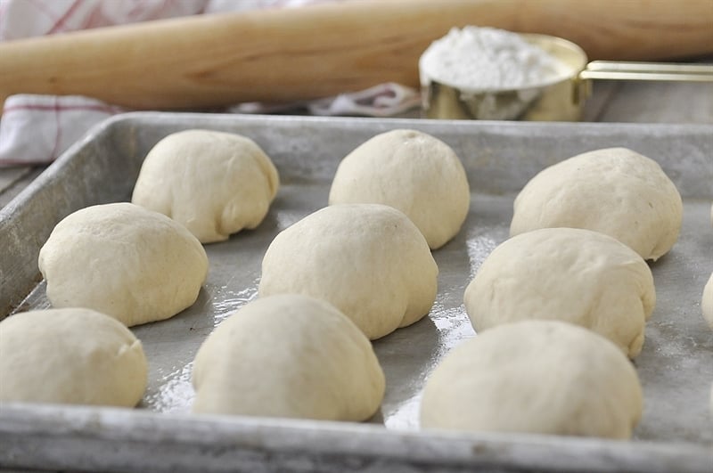 Dinner rolls rising on baking sheet