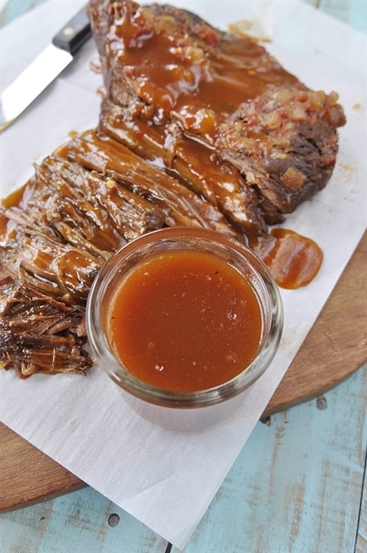 sliced brisket with a side of sweet and sour brisket sauce