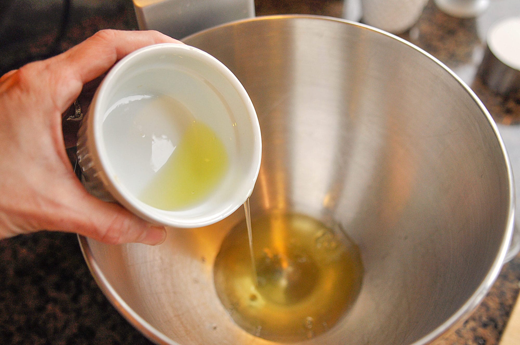 adding egg whites to bowl