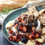 plate of baked brie with fruit on topo