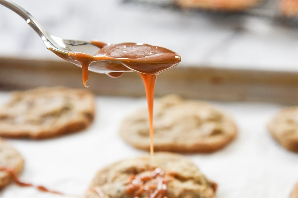 drizzling caramel over chocolate caramel cookies