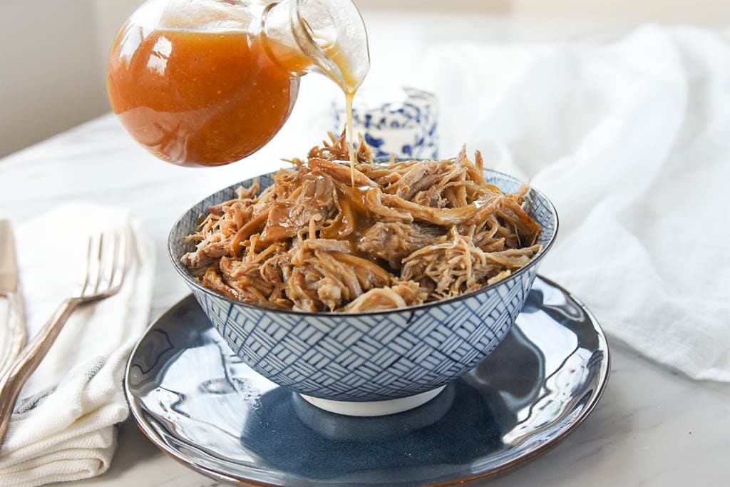 pouring maple glaze over maple pulled pork