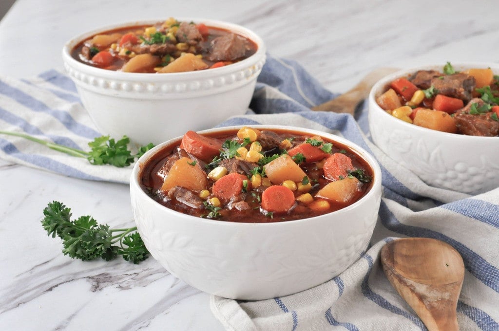 bowl of steak soup with potatoes carrots corn