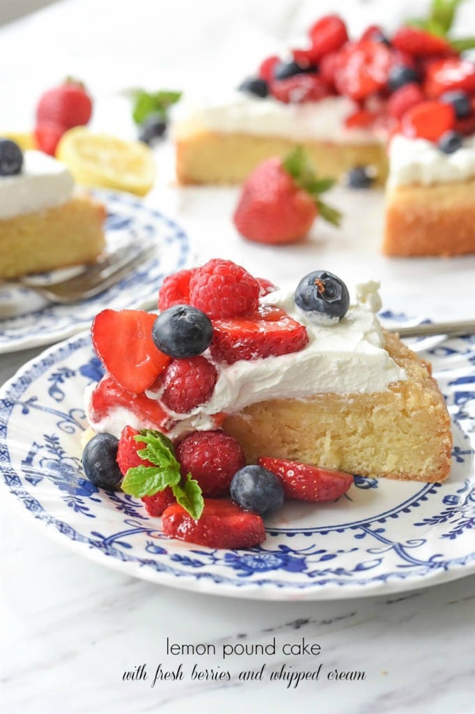 A slice of Lemon poundcake topped with fresh berries and whipped cream