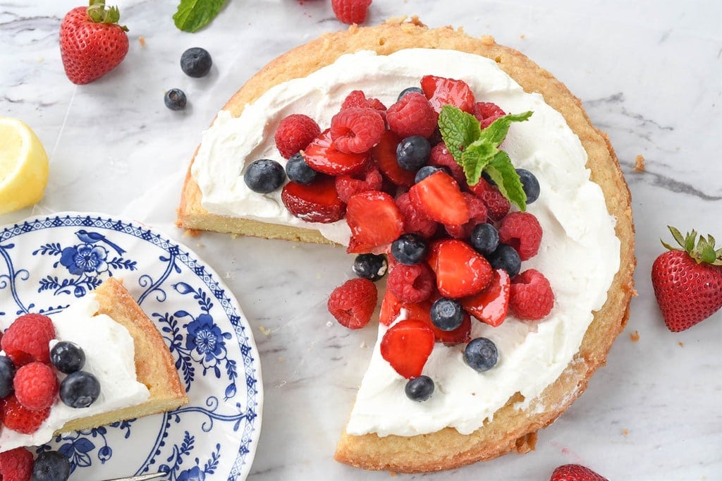 a slice of lemon pound cake served with whipped cream and fresh berries