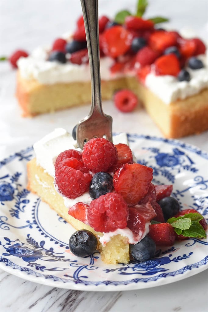 a fork stuck in a slice of lemon pound cake topped with berries