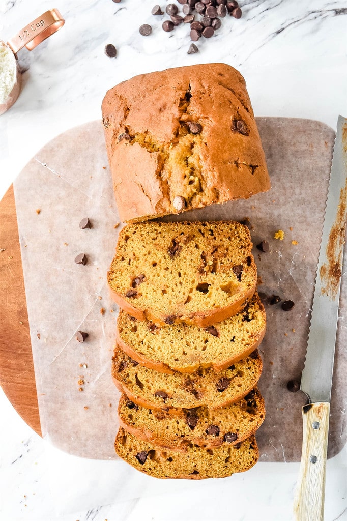 slicing Pumpkin Chocolate Chip Bread on parchment paper