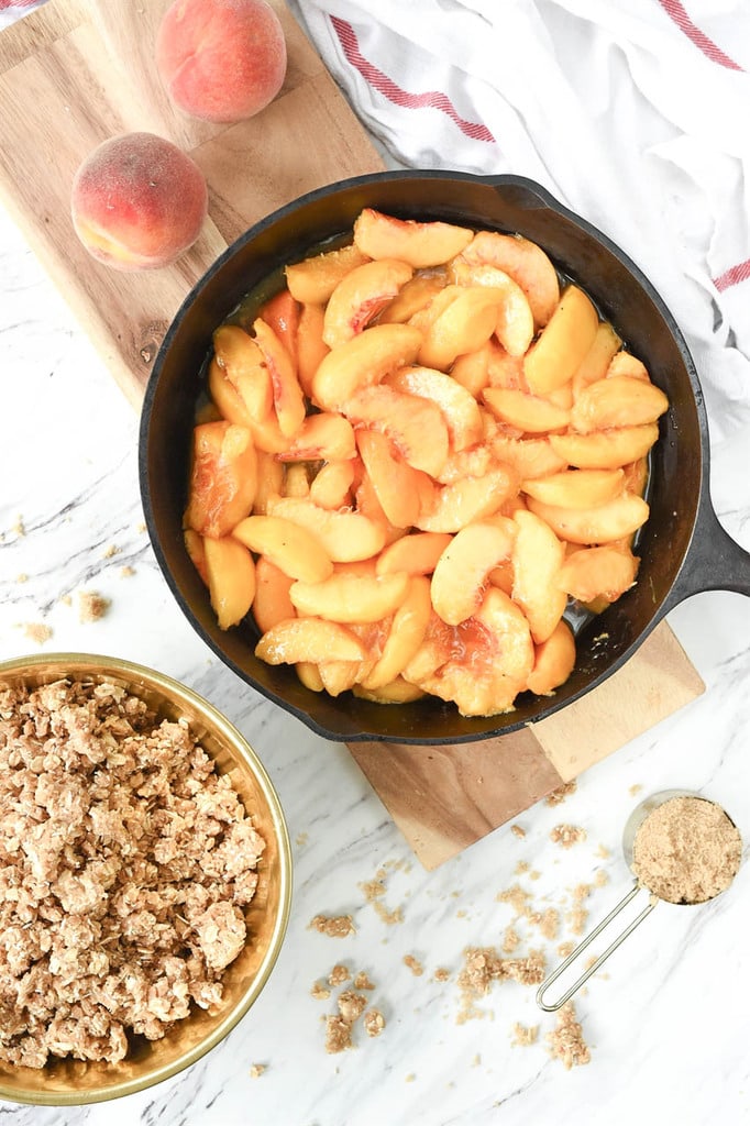 sliced peaches in a cast iron skillet