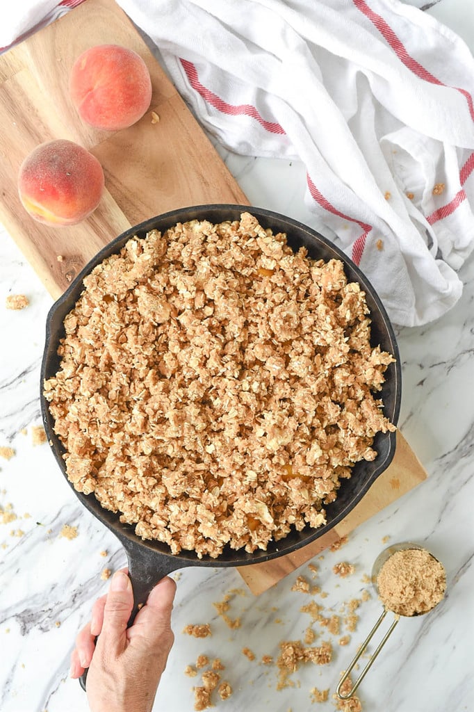 Peach Crisp in a cast iron skillet ready for the oven