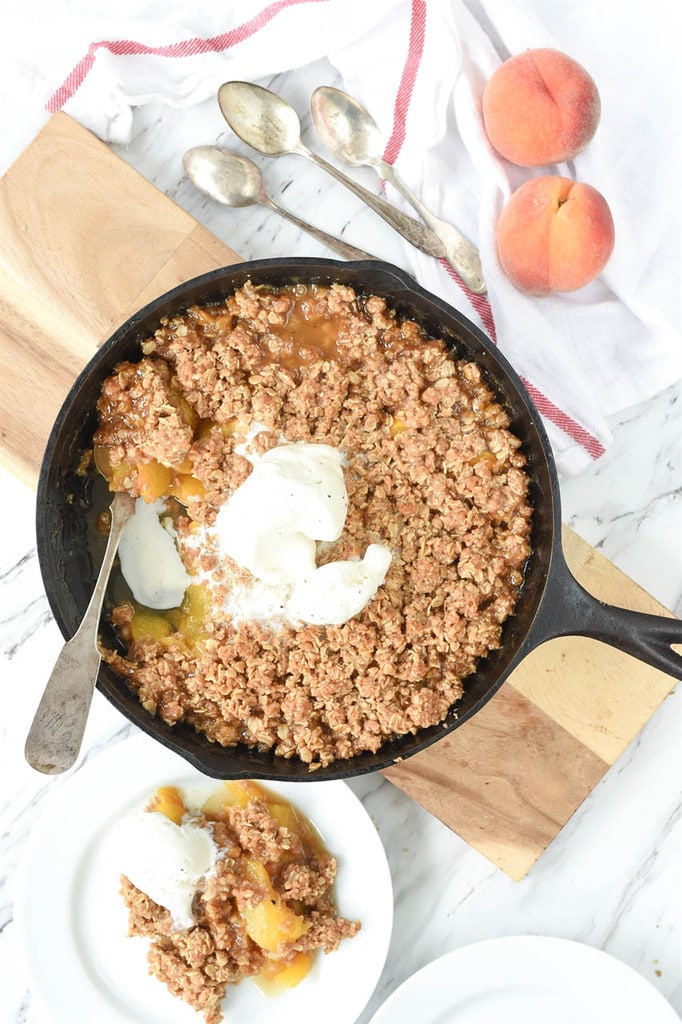 cast iron pan full of peach crisp