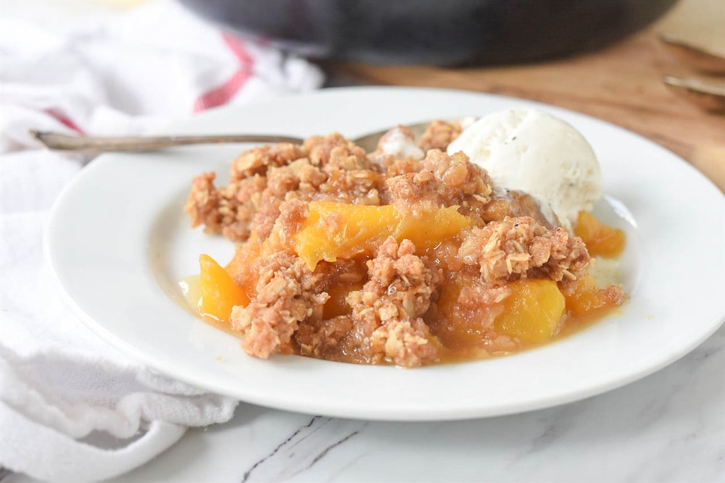 Peach Crisp on a plate with ice cream