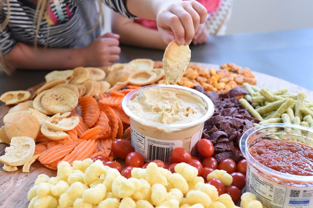 pita chip being dipped in hummus