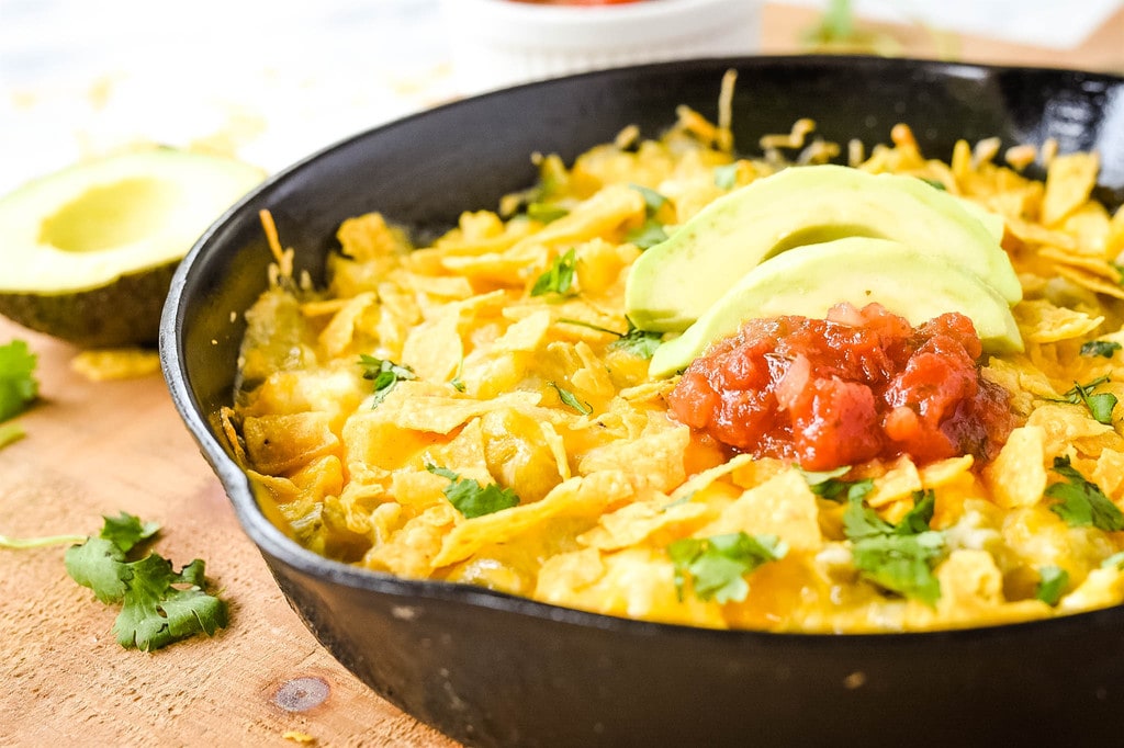 green chili egg casserole topped with tortilla chips avocado and salsa