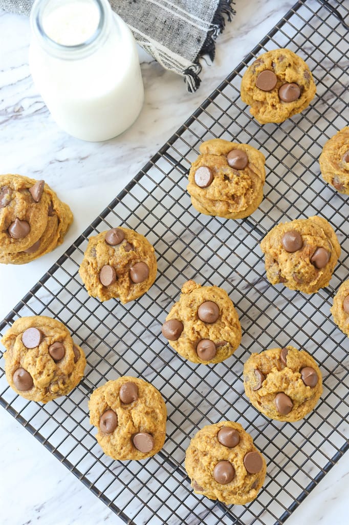 Pumpkin Chocolate Chip Cookies on a rack with a bottle of milk