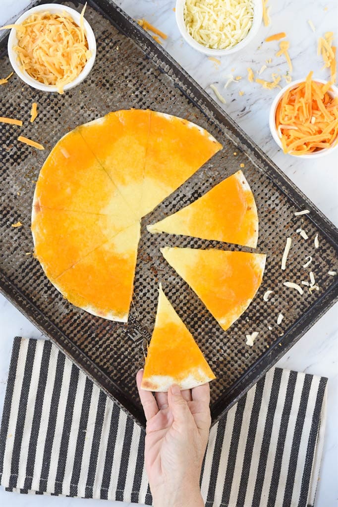 a hand grabbing a slice of candy corn quesadilla