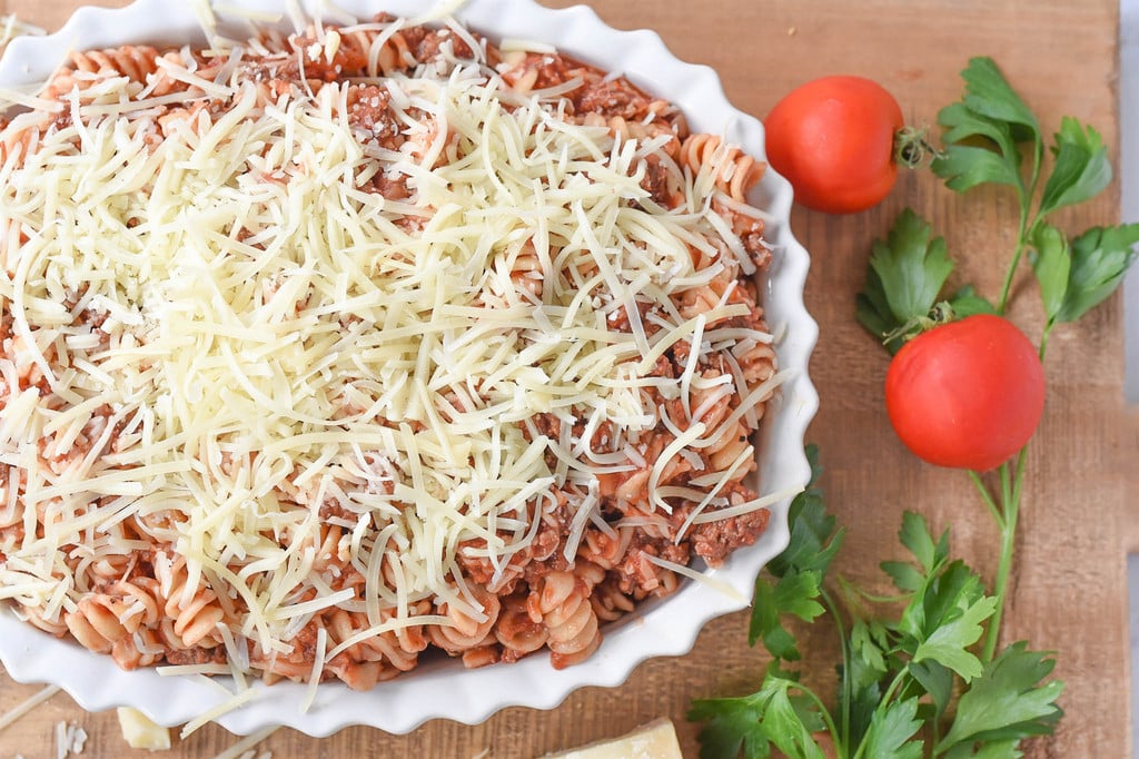 fussili pasta and meat sauce covered in mozzarella cheese