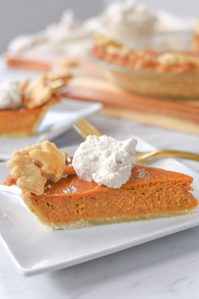 Pumpkin Pie on a plate with whipped cream on top