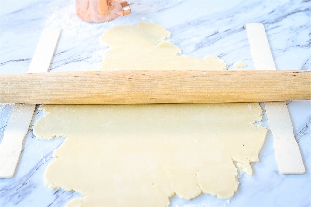 rolling out decorated sugar cookie dough