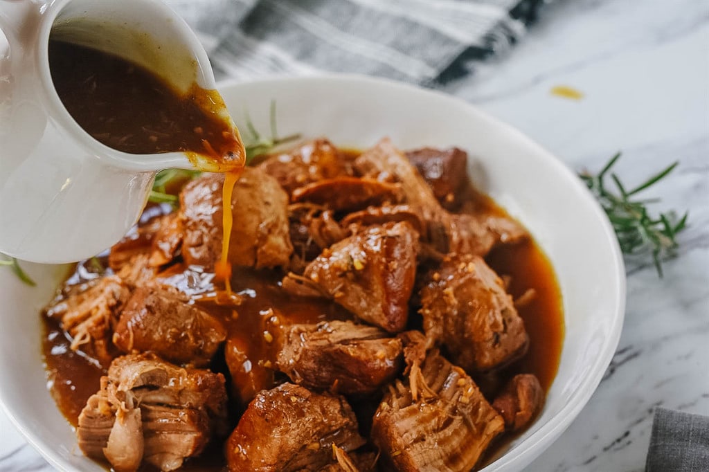 Pouring balsamic sauce over pork Tenderloin