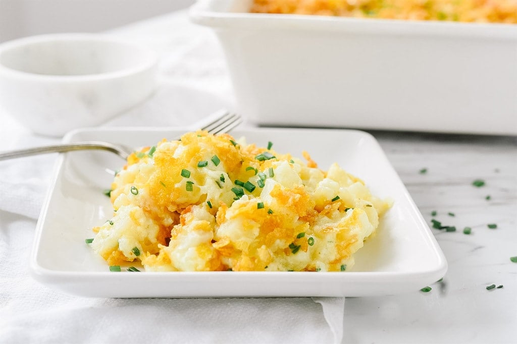 Cheesy potatoes on a white plate