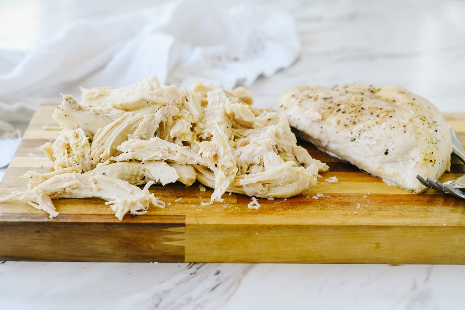 shredded chicken on a cutting board