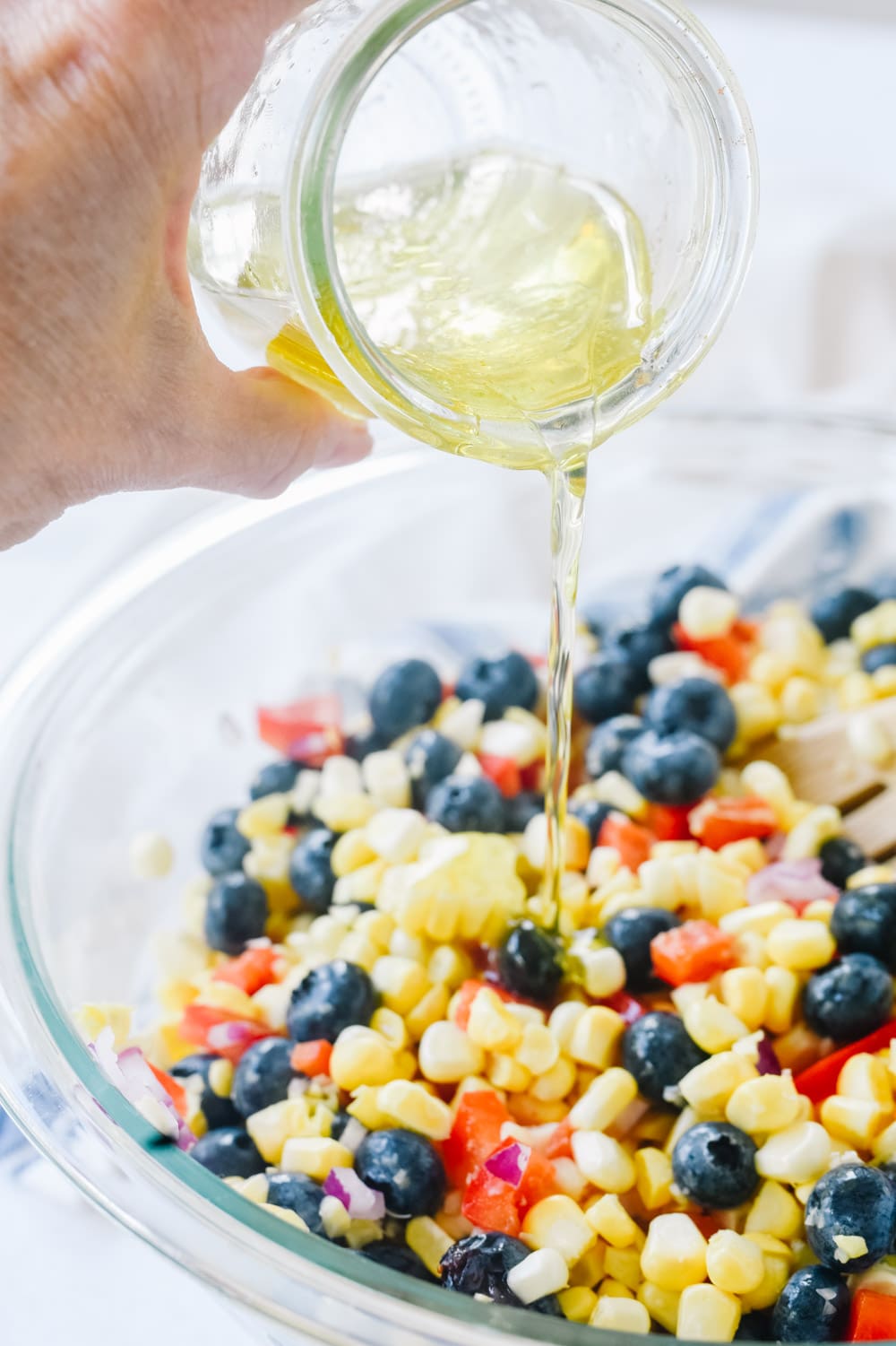 Pouring dressing on Blueberry Corn Salad