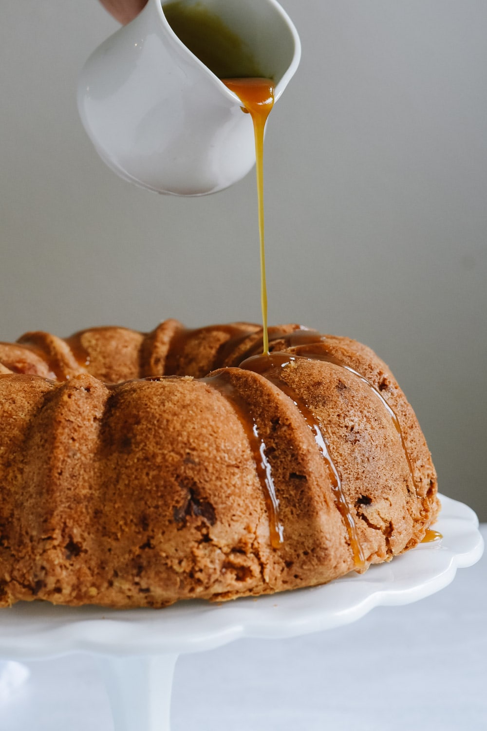 pouring caramel over apple bundt cake