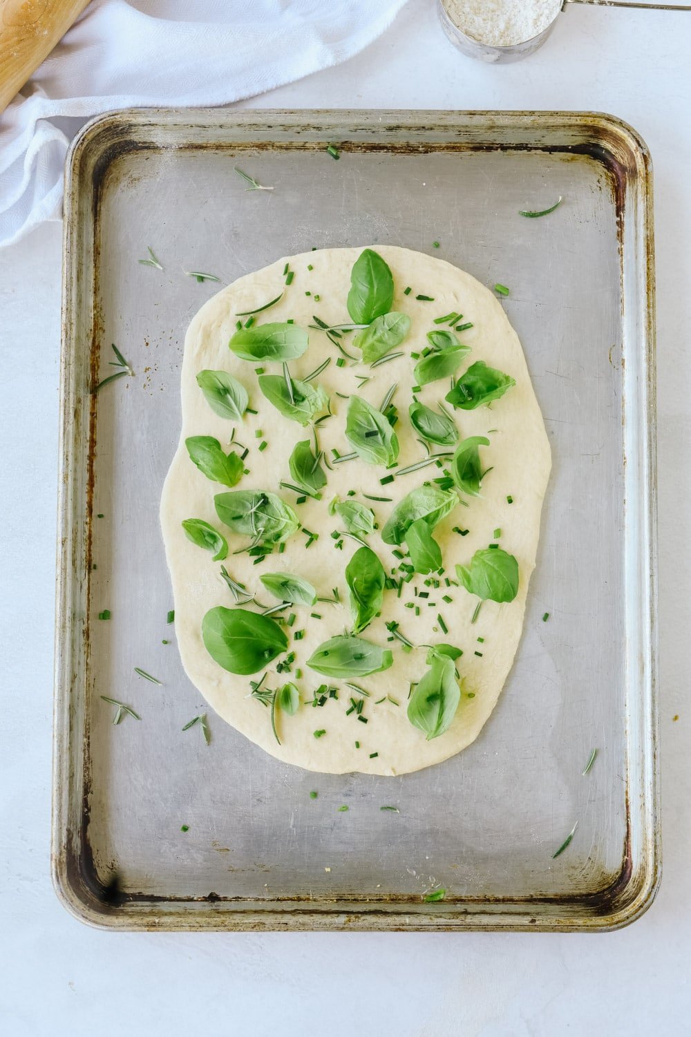 flatbread dough with herbs on it.
