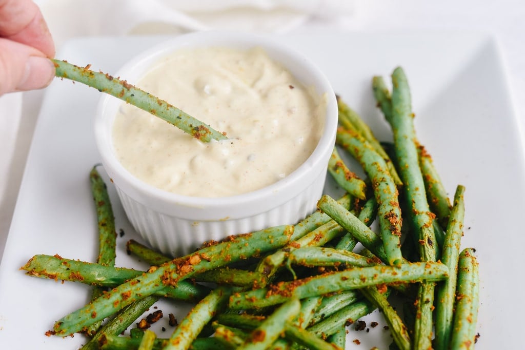 dipping pan seared green beans into a remoulade sauce