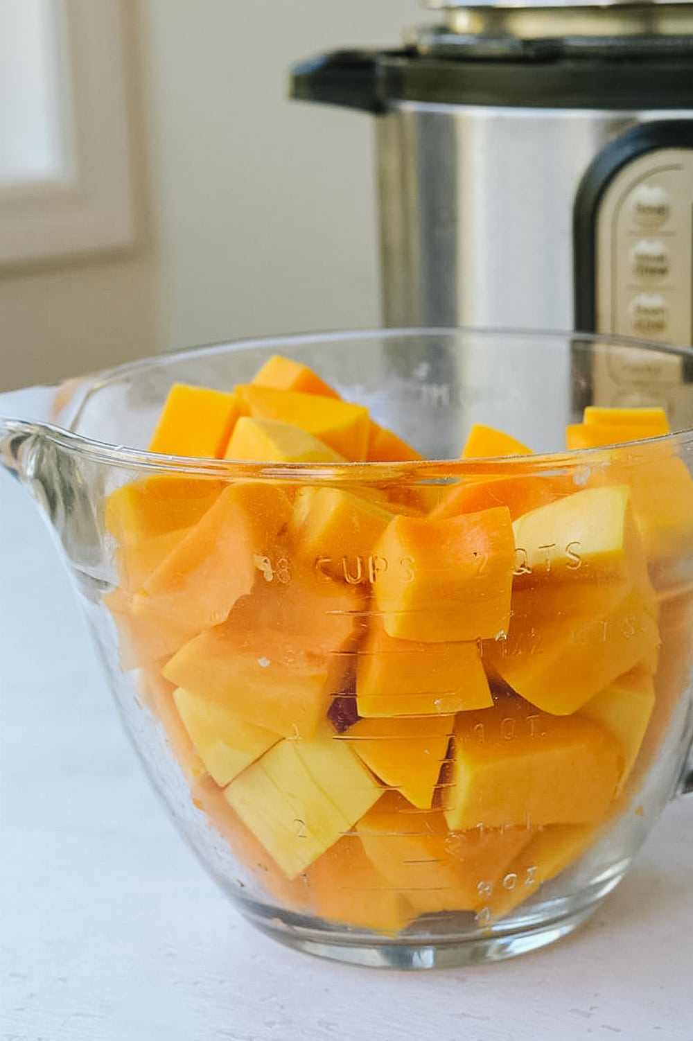 Cubed butternut squash in measuring cup