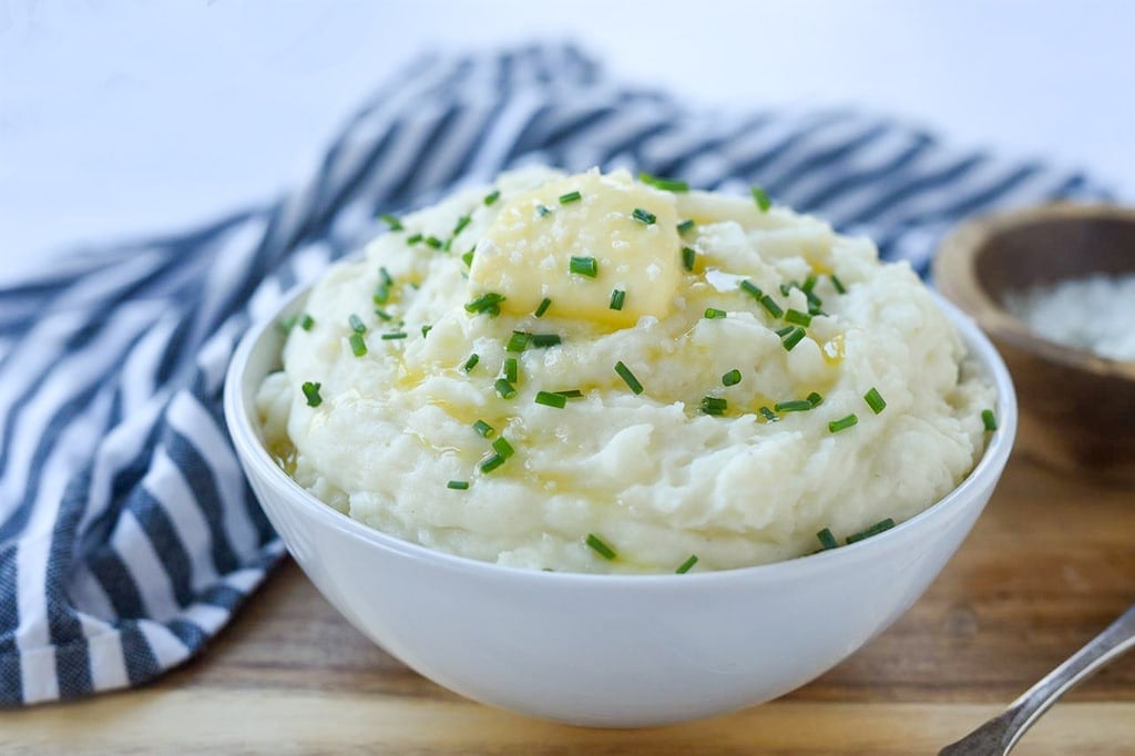 bowl of mashed potatoes on a cutting board