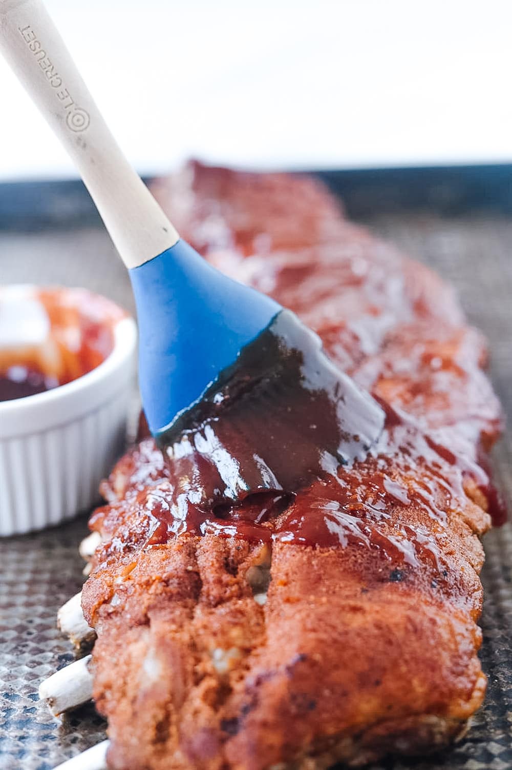 brushing BBQ sauce on ribs