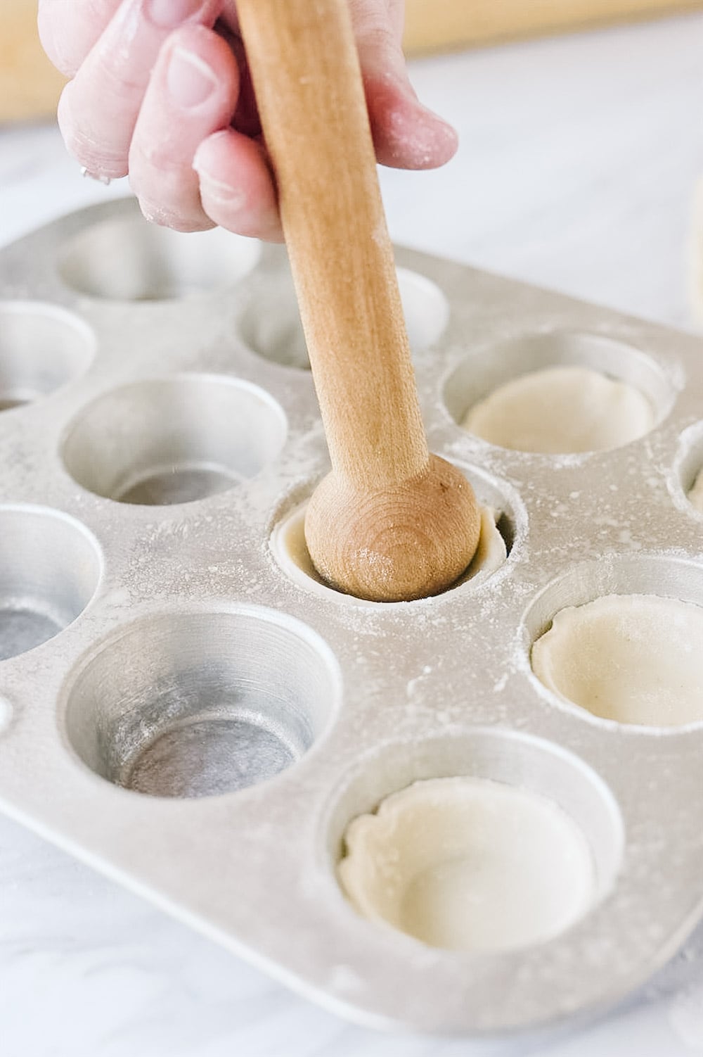 pushing dough into muffin tin