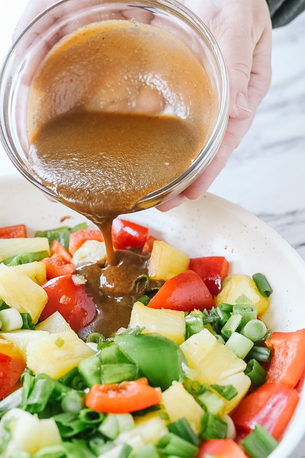 pouring sauce over sweet and sour pork