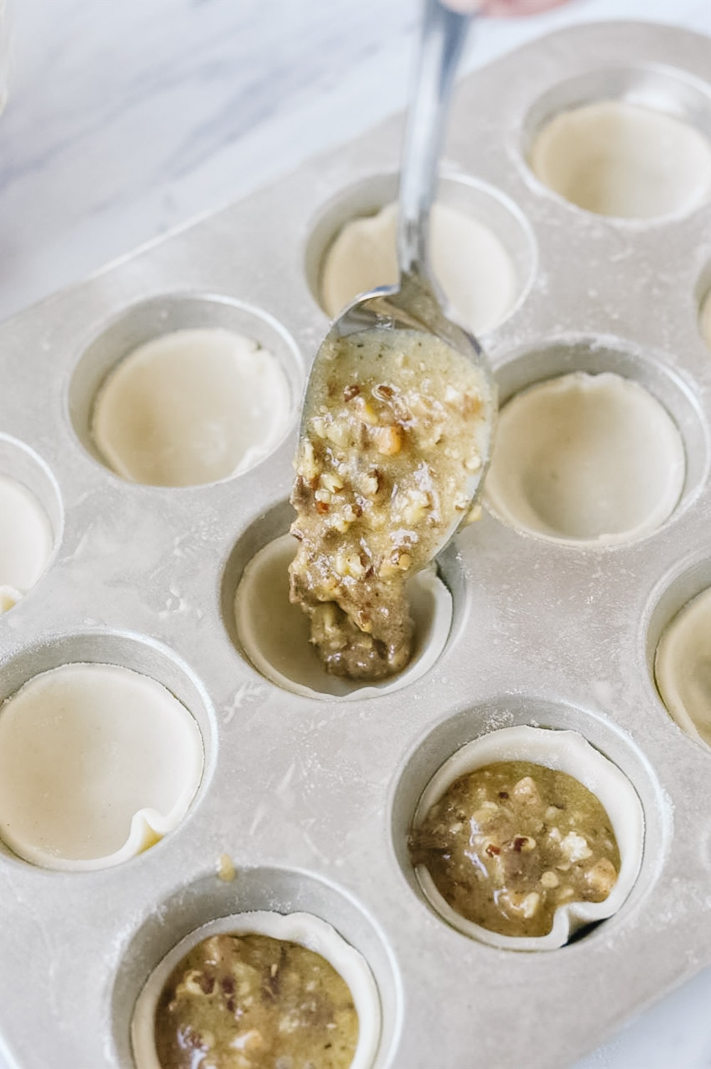 Filling tarts with pecan tassie filling.