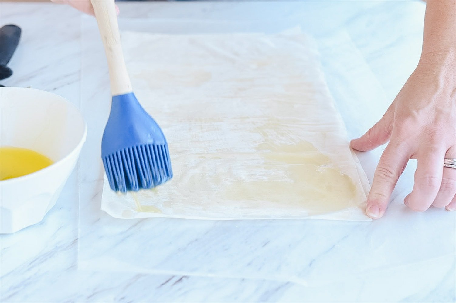 brushing phyllo dough with melted butter