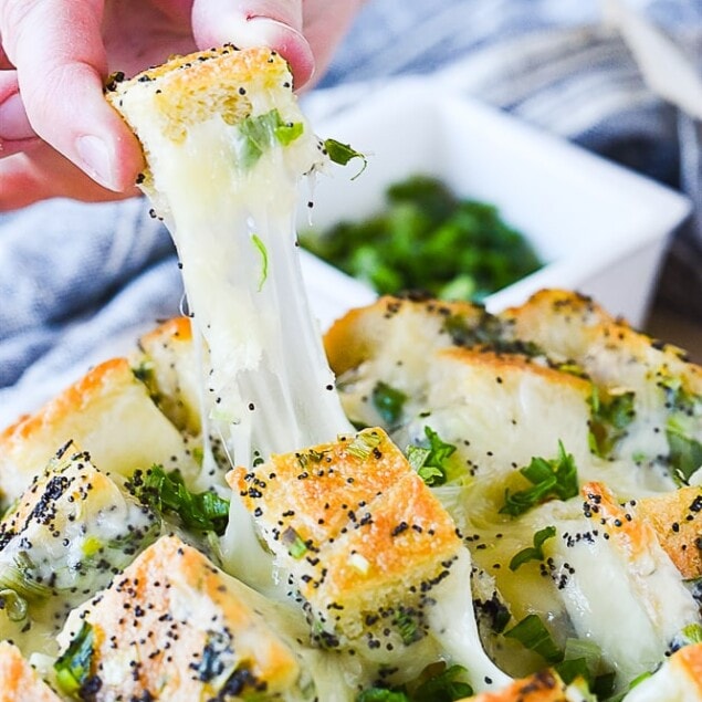 hand pulling cheesy bread